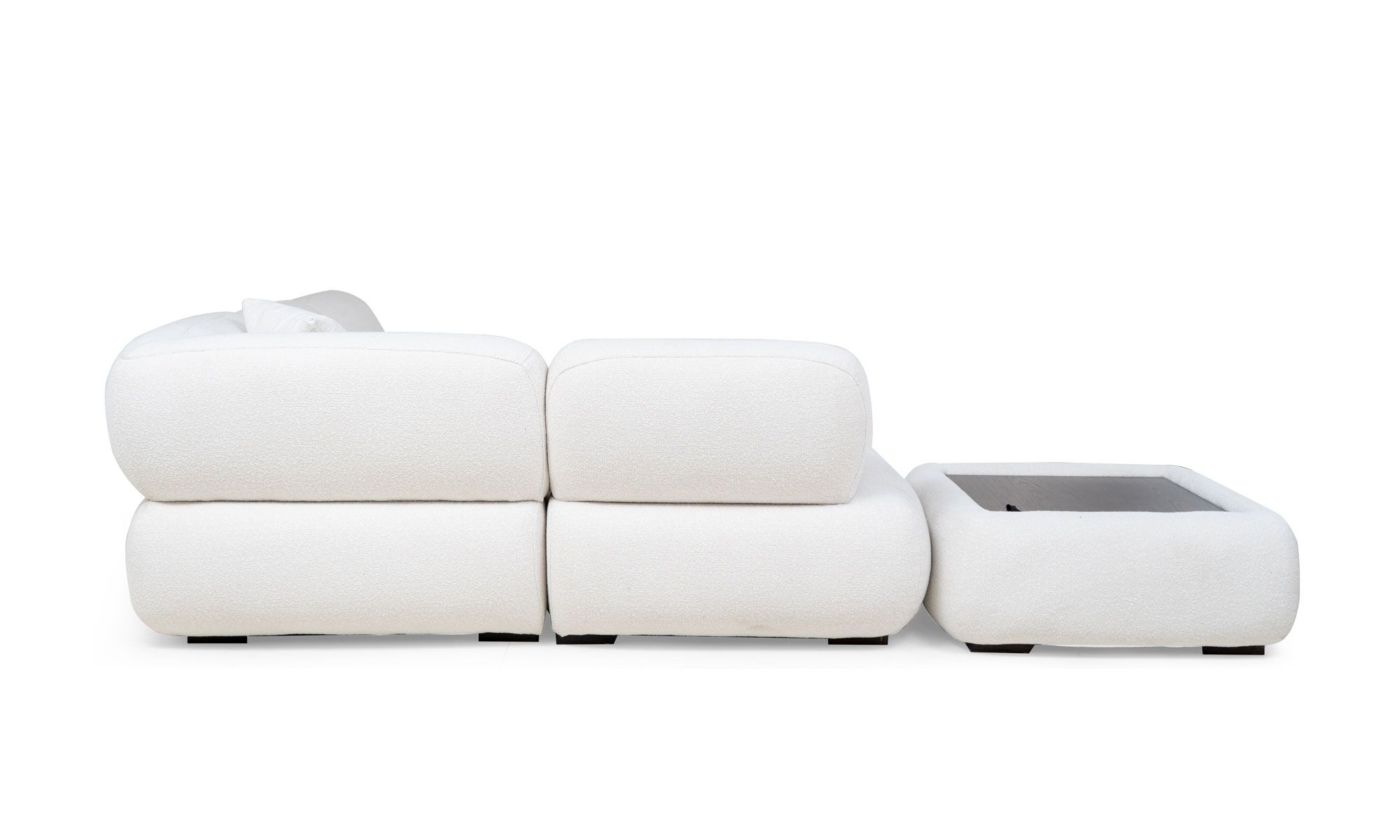 espalda emma L esquine+puff Vista posterior de la Sala en L Modular Emma Esquinero + Puff de Aristas. Un diseño elegante de líneas curvas, con un tapizado en tela suave y cojines gruesos en los asientos y respaldos. Las patas cortas y discretas del sofá y puff complementan el conjunto.