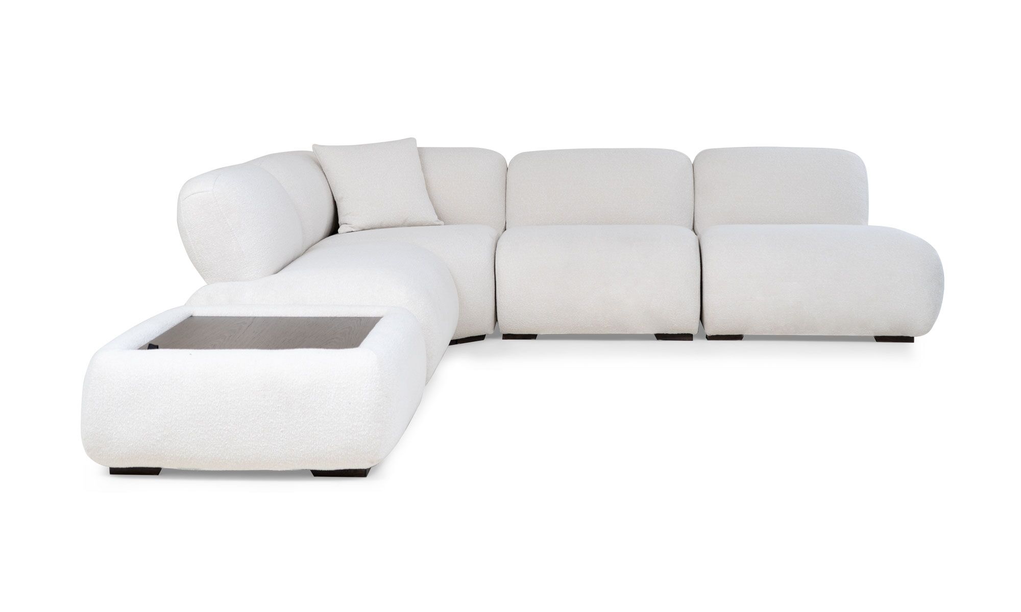 lado emma L esquine+puff Vista frontal de la Sala en L Modular Emma Esquinero + Puff de Aristas. Un diseño elegante de líneas curvas, tapizado en tela suave y cojines gruesos en los asientos y respaldos. El esquinero está compuesto por varias secciones modulares, y el conjunto incluye un puff a juego.