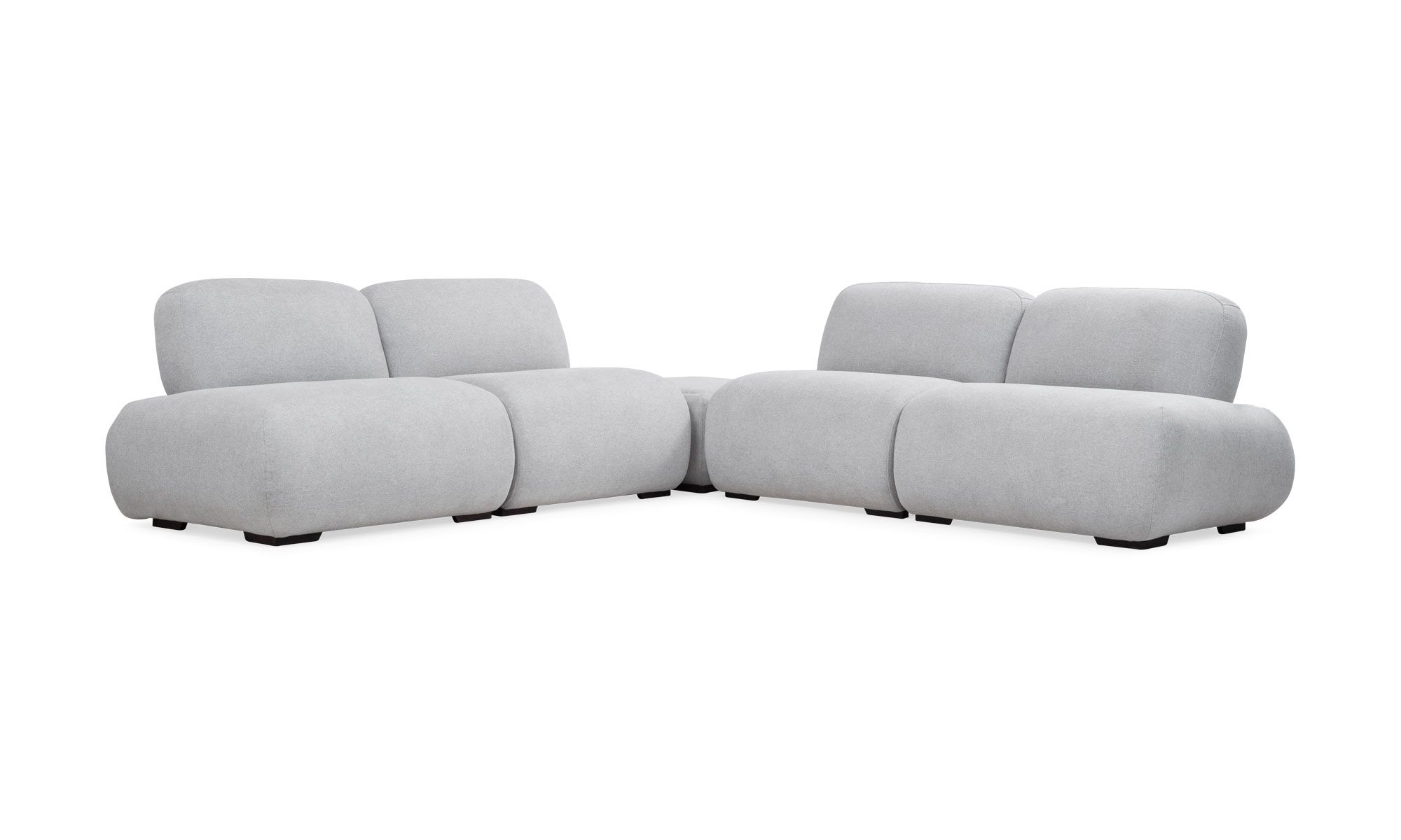 2.SALA-EN-L-MODULAR-EMMA-PUFF-TAPIZADO Sala en L Modular Emma con Puff de la marca Aristas vista en perspectiva diagonal. Presenta un diseño elegante de líneas curvas, con asientos tapizados en tela suave y patas discretas en madera