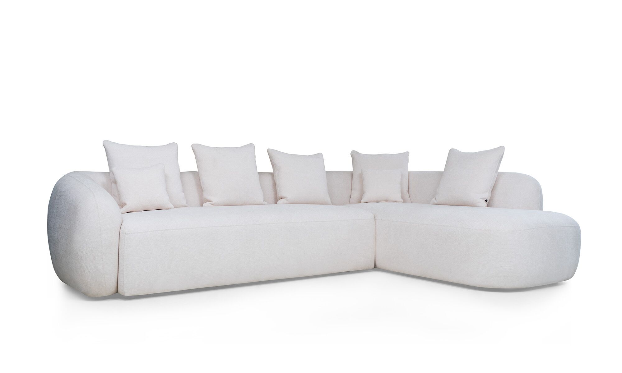 3,4 L DEMAND Sala en L Modular Demand de la marca Aristas, vista en diagonal. Presenta un diseño elegante de líneas curvas, con un espaldar amplio y un tapizado suave en el color de tela Dickens Cuarzo.