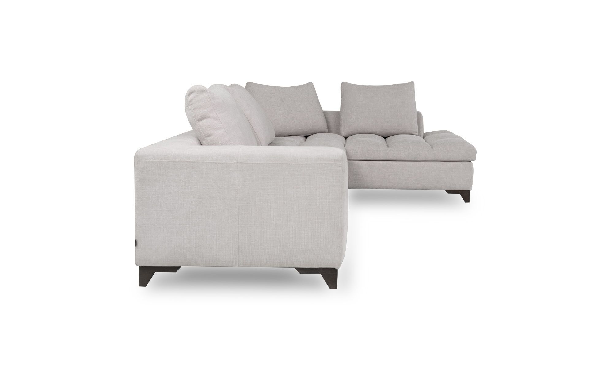 Sala En L Modular Vitaro Plus Plumas lado Vista lateral de la Sala En L Modular Vitaro Plus Plumas de Aristas. Este sofá modular presenta un diseño amplio y moderno, con asientos profundos. Los cojines del respaldo y los asientos tienen un acabado en tela suave.