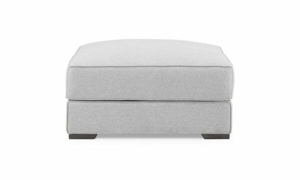 Vista frontal del Puff Roma de la marca Aristas. Este puff compacto tiene un diseño cuadrado y elegante, con un tapizado uniforme en tono neutro y patas discretas en madera.