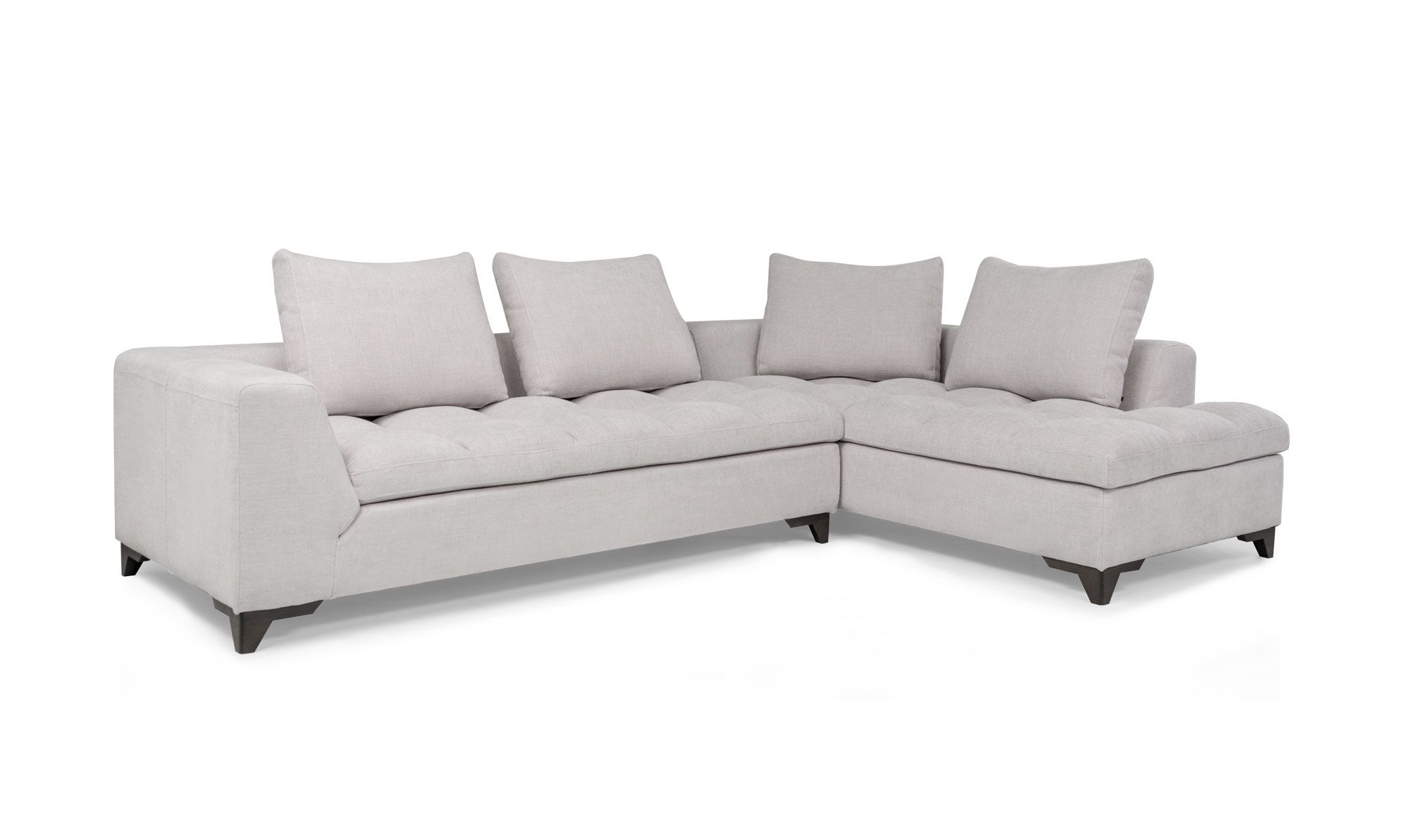 Sala En L Modular Vitaro Plus Plumas 3,4 Vista diagonal de la Sala En L Modular Vitaro Plus Plumas de Aristas. Presenta un diseño amplio y moderno, con asientos acolchados y un acabado en tela suave. Las patas son discretas en madera y complementan su estilo contemporáneo.