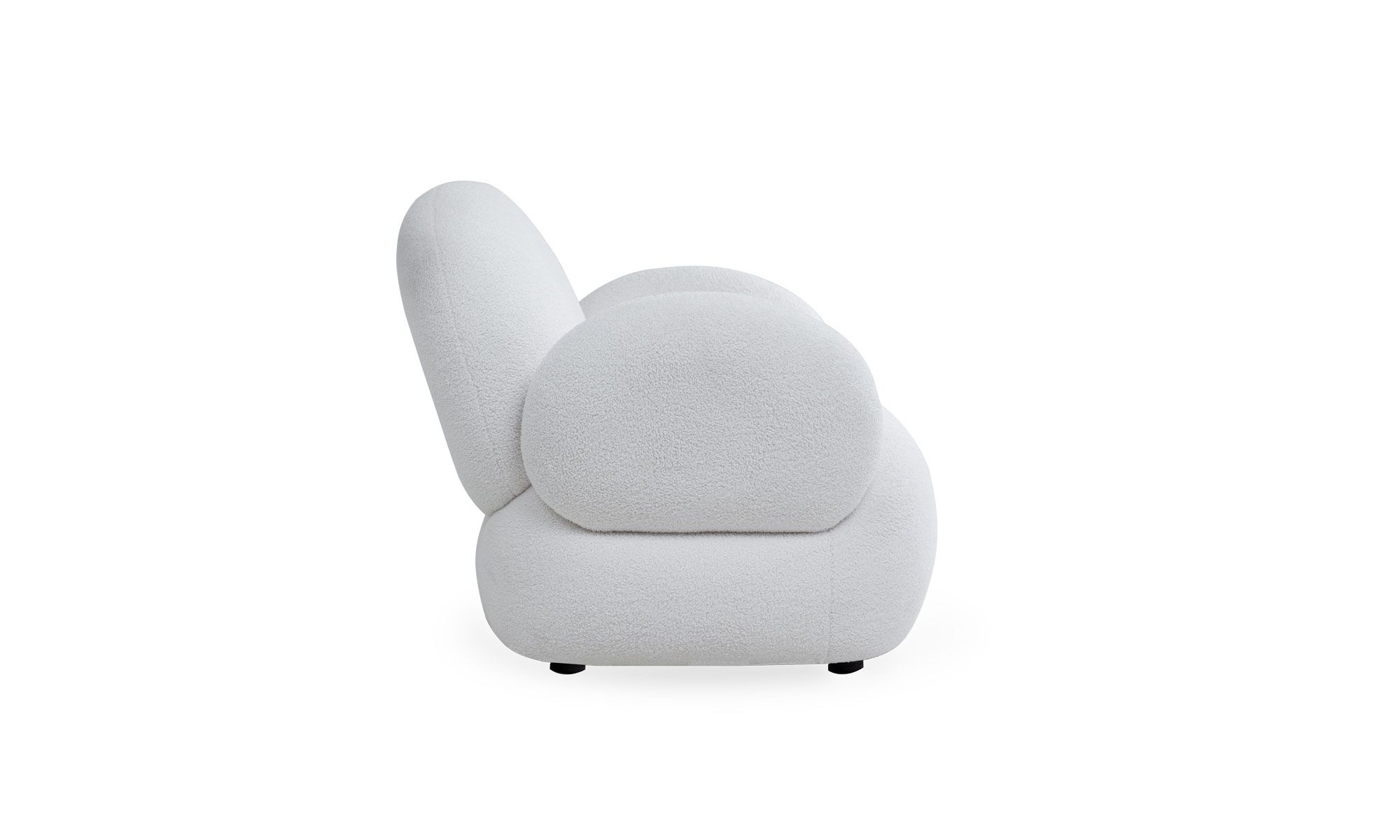 lado NIZA Vista lateral de la poltrona Niza de la marca Aristas. Destaca por su diseño elegante y contemporáneo, con un respaldo suavemente inclinado para mayor comodidad y brazos anchos que aportan un toque de sofisticación en el color de tela Boucle Blanco