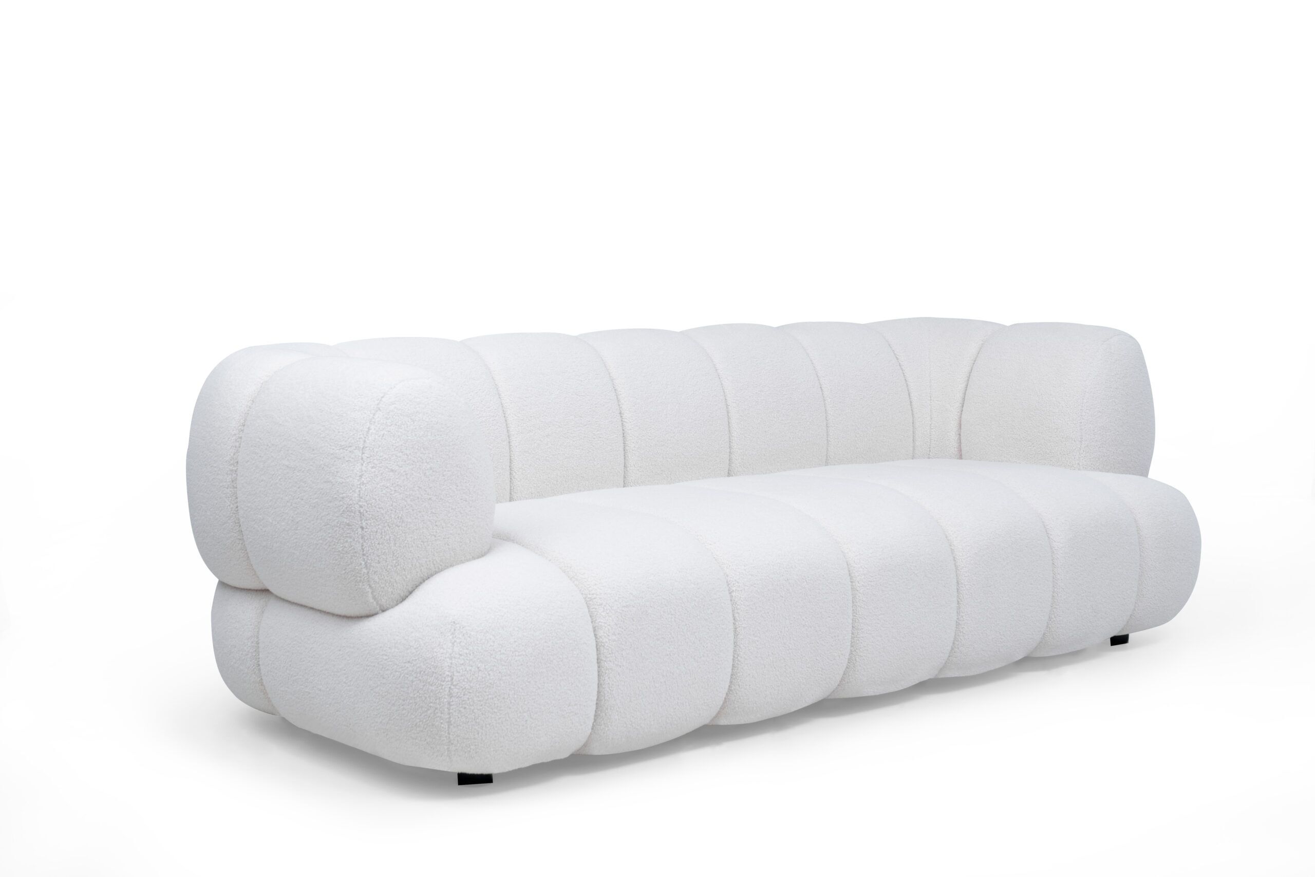 Sofa-estambul-3-puestos-3,4 Vista diagonal del Sofá Estambul de la marca Aristas. Un diseño elegante y contemporáneo de líneas curvas, con un tapizado suave y patas discretas en madera.