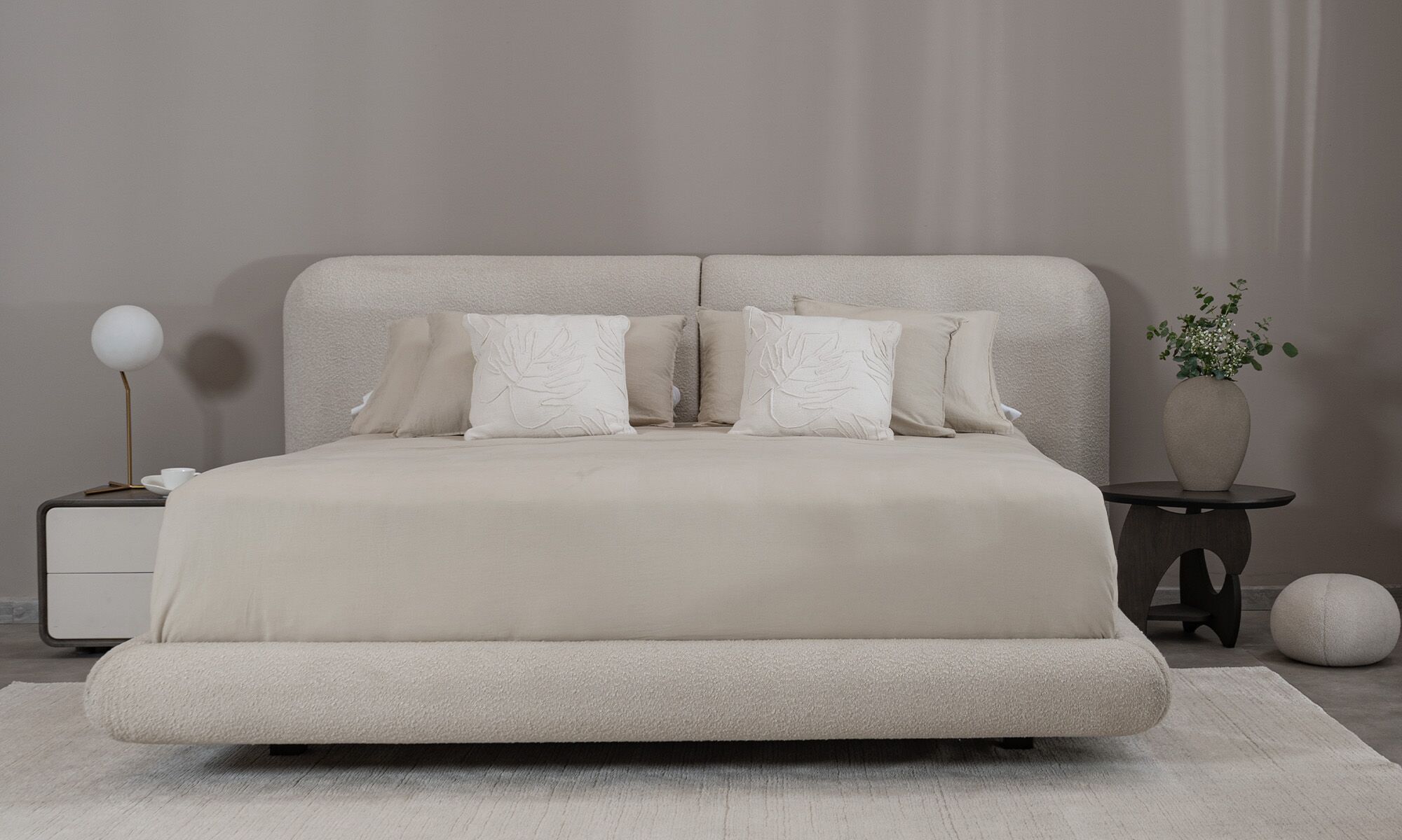 recor Vista frontal de la Cama Milán de la marca Aristas. Un diseño elegante y minimalista que destaca por su cabecera acolchada de líneas curvas y tapizado suave.