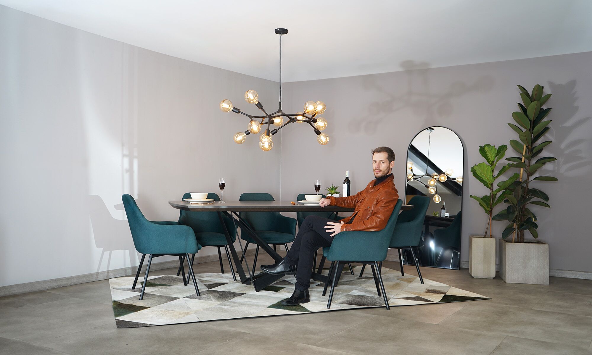 Comedor Versalles con modelo + Sillas Turin Mesa Comedor Versalles con 8 sillas Turín P/N de la marca Aristas vista en perspectiva diagonal. La mesa presenta un diseño con una superficie rectangular en madera color Chocolate. Las sillas Versalles, cuentan con respaldos curvos, asientos acolchados y patas rectas en metal.