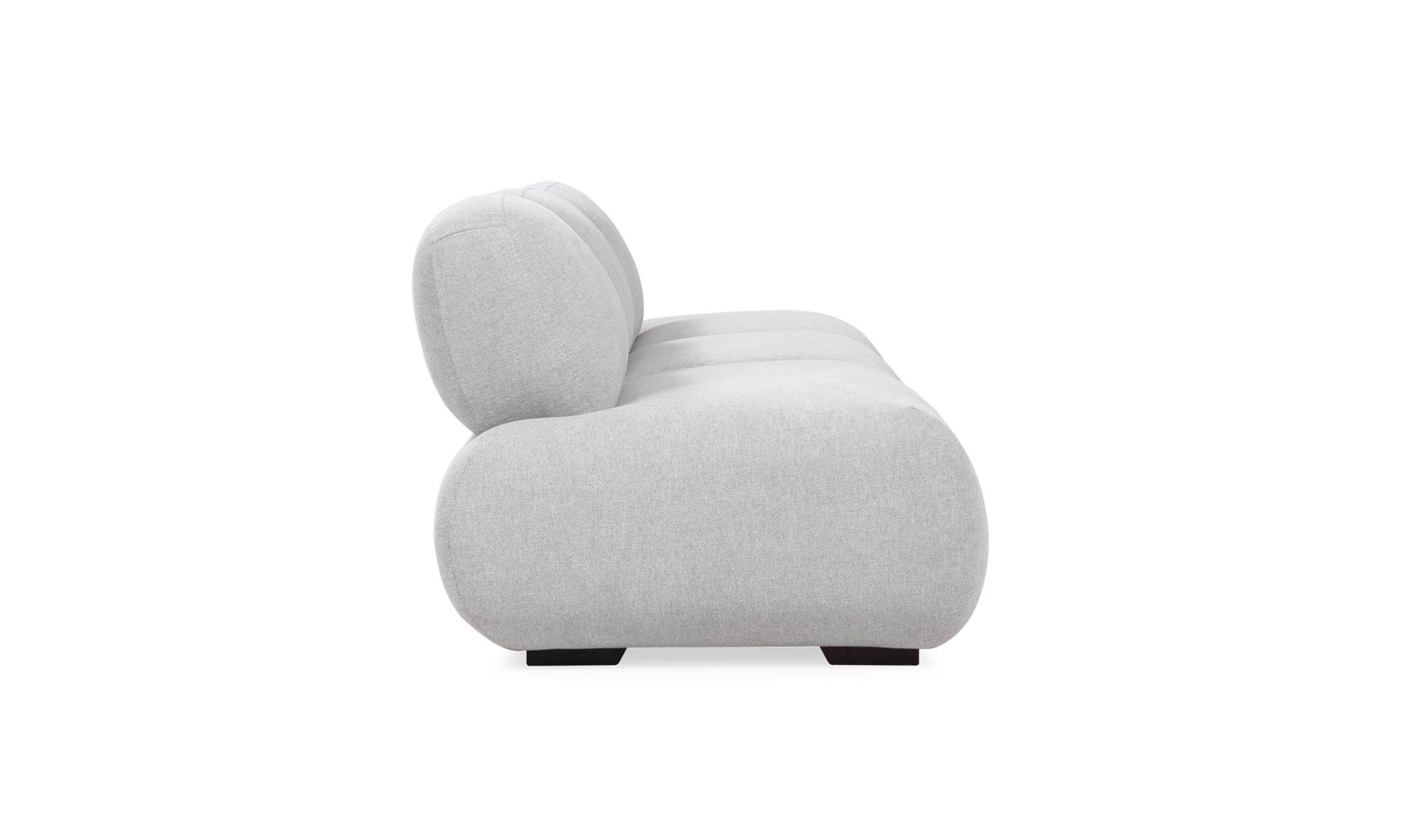 3.SOFA-EMMA-3P Sofá Modular Emma de la marca Aristas visto en perspectiva lateral. Un diseño moderno y elegante de líneas curvas, con un asiento y espaldar acolchado, tapizado en tela suave de color neutro.