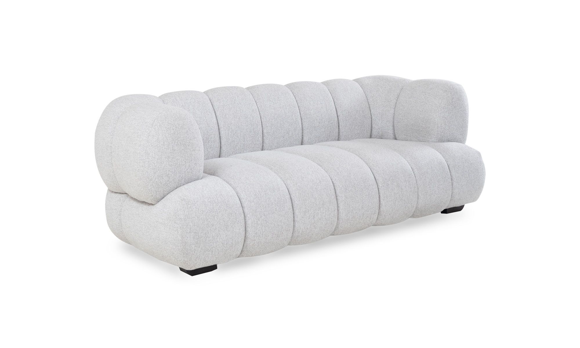 3,4 estambul palatino Vista diagonal del Sofá Estambul de Aristas. Este sofá destaca por su diseño elegante y contemporáneo. Tiene tapizado en tela de color neutro, patas discretas en madera y líneas curvas.