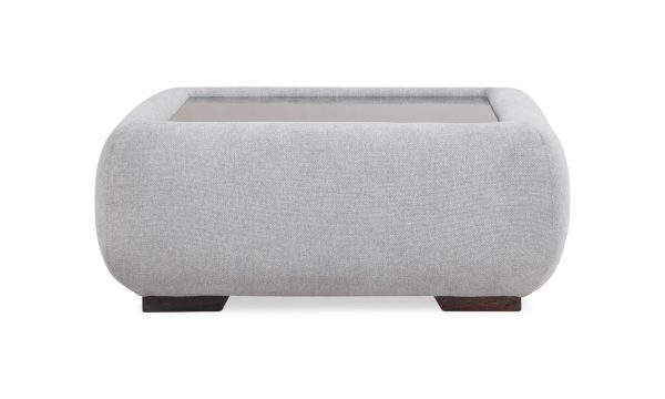 Vista frontal del Puff Baúl Emma de la marca Aristas. Un diseño elegante con un tapizado en tela suave, tapa en madera y patas discretas.