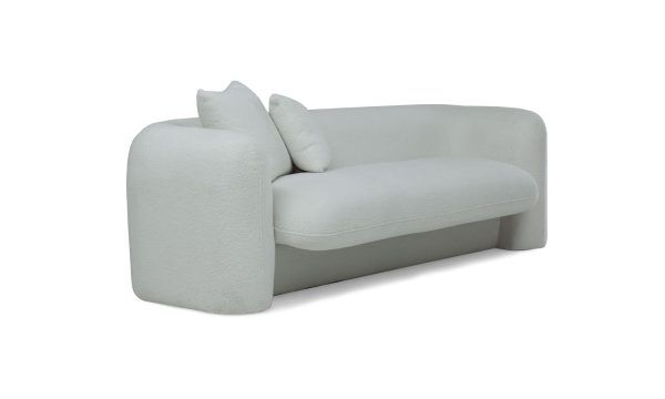 Sofá Milan de la marca Aristas, visto en perspectiva diagonal. Un diseño moderno y elegante de líneas curvas y cojines acolchados en el color de tela Boucle Blanco.