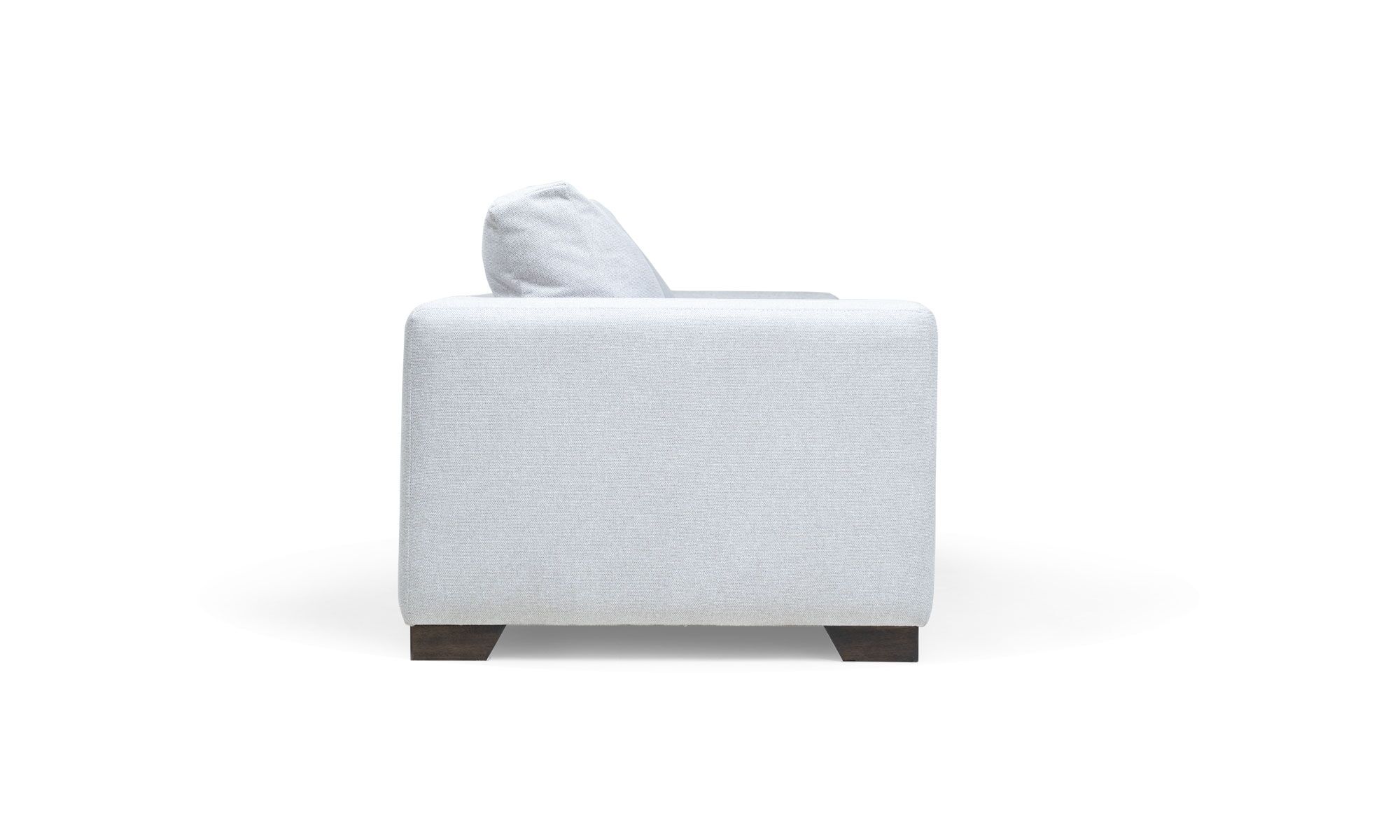 Sofa-new-belt-3-puestos-lado Sofá New Belt Plumas de la marca Aristas visto en perspectiva lateral. Un diseño amplio con cojines acolchados, respaldo bajo y patas discretas en madera.